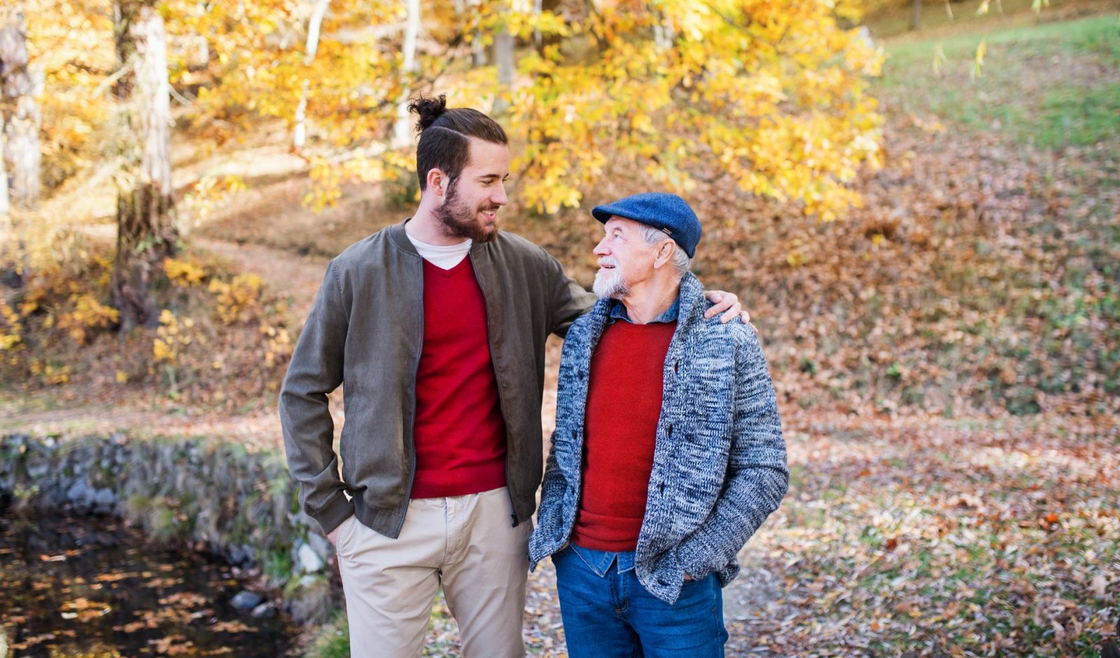 A senior man and his son go for a walk on a fall day